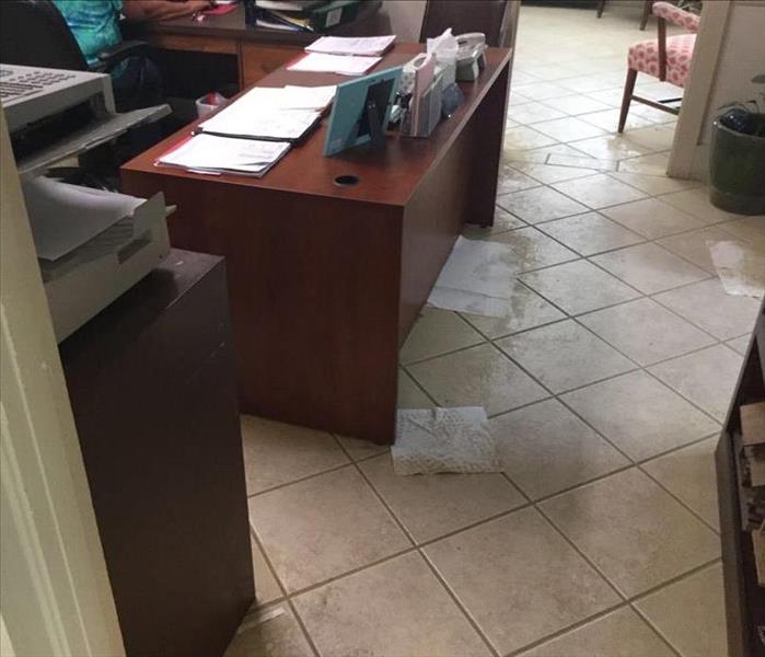 office with wet tile floor and wet paper towels on the floor