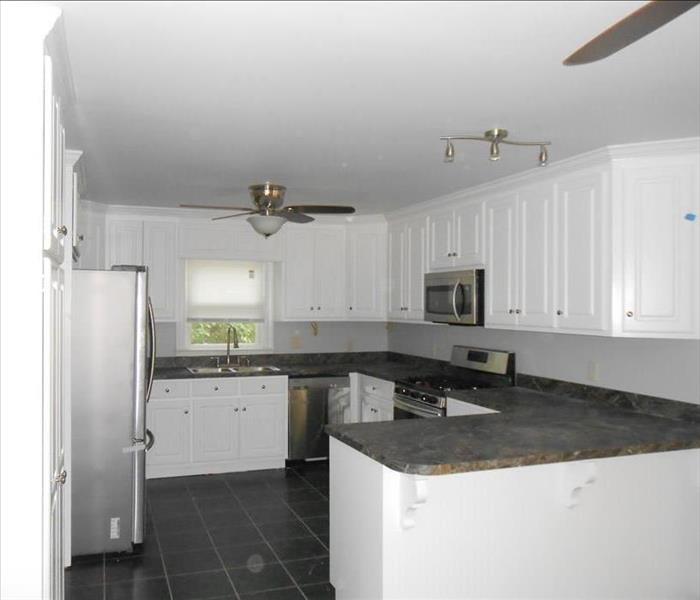same kitchen with new white cabinets and ceiling, new granite countertops
