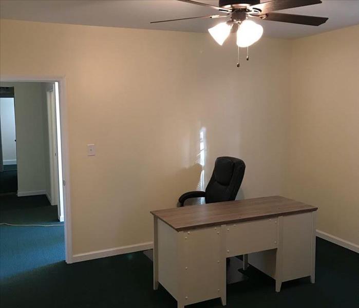 Pastor's office in repaired church, freshly painted walls, new carpet and new desk
