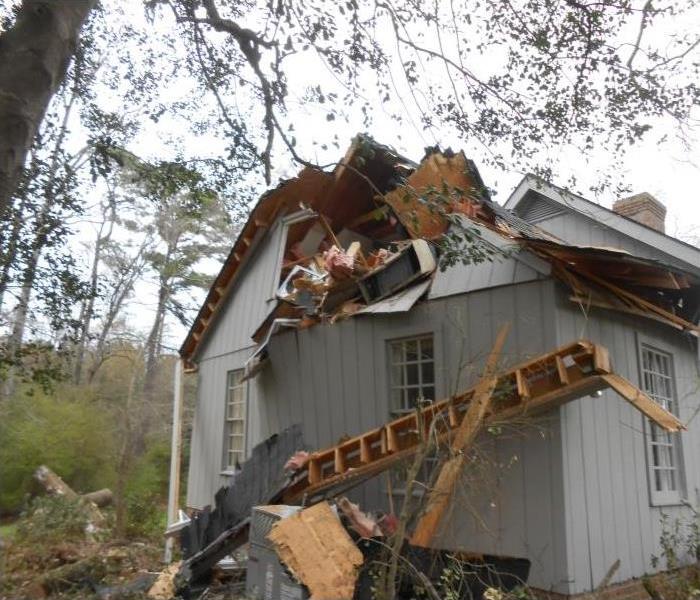 house that was damaged from a large tree falling on it
