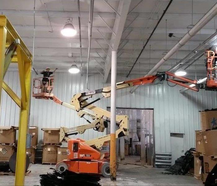 Technician on a lift in a warehouse that needed cleaning