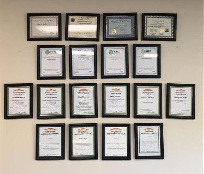 Wall in the office showing certifications in frames