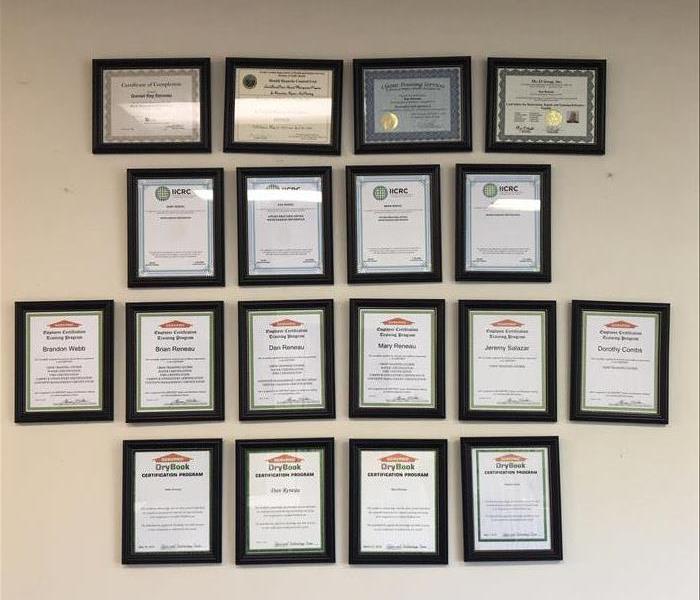 Rows of framed certifcates on wall